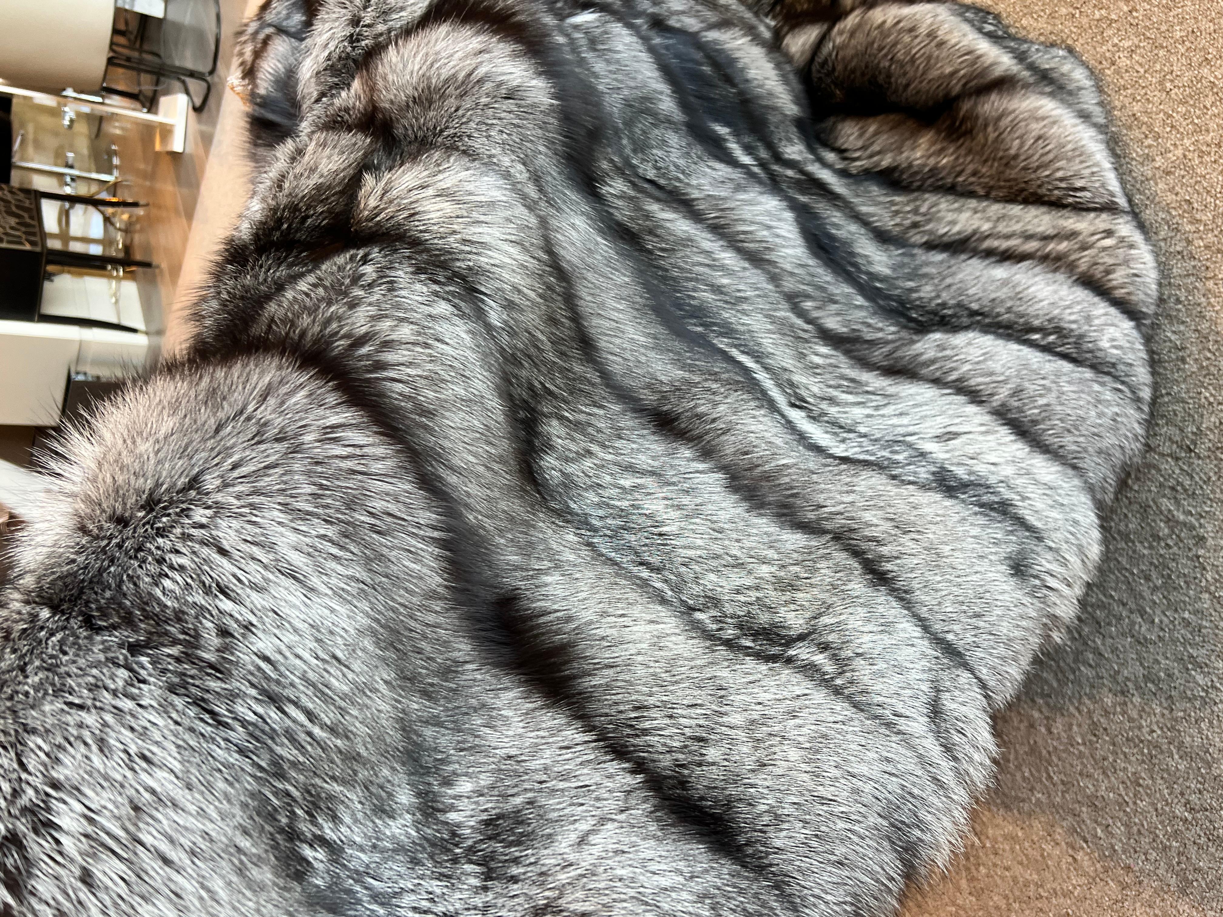 Ce grand jeté doublé de soie de renard argenté est fabriqué à partir des peaux naturelles de renard canadien les plus denses et les plus fines.
La doublure en soie confère à cette pièce un aspect doux et lisse qui se fond dans votre corps.
Cette