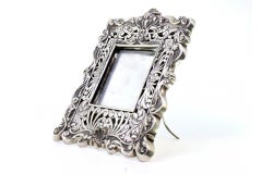 Silver frame cut with shell reliefs and support stand