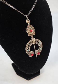 Silver French penannular brooch set with cabochons of red coral and turquoise