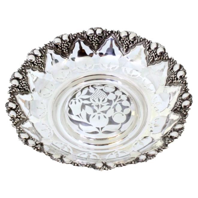 Silver fruit bowl cut into the shape of fruit with reliefs on the outside