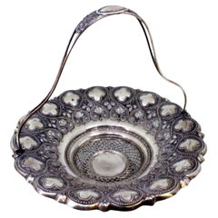 Silver fruit bowl w/ embossed floral motifs, hinged handle w/ monogram insert