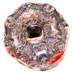 Silberne Obstschale mit Muschelreliefs und floralen Motiven, die Monogrammkarten umgeben