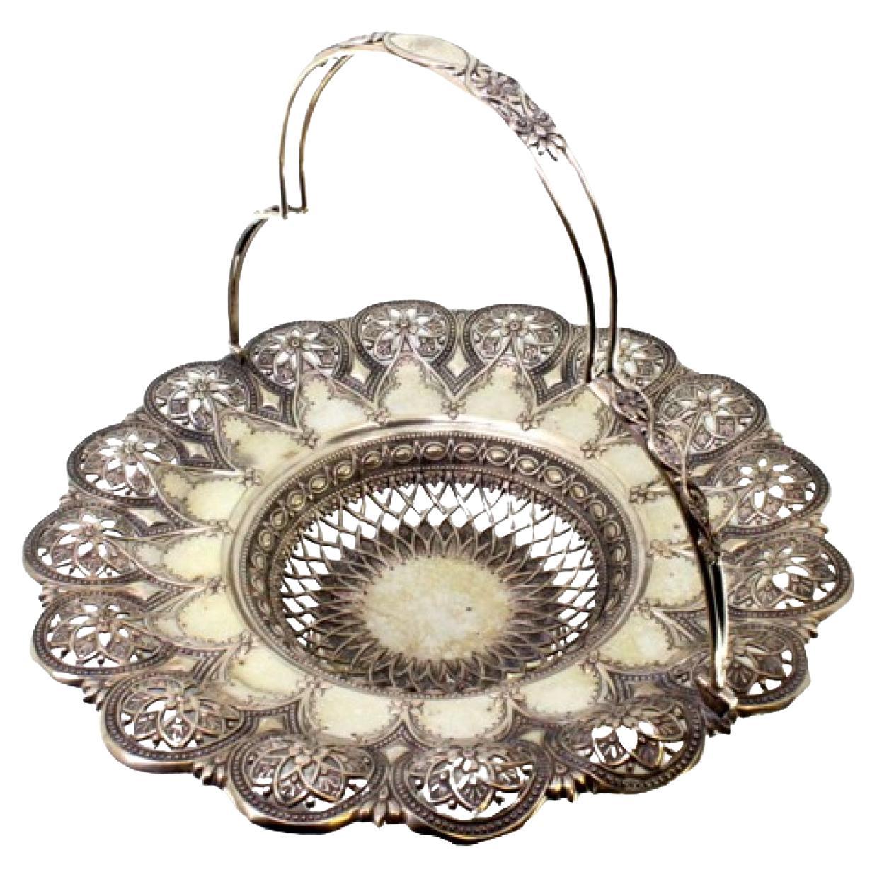 Silver fruit bowl with cutouts, floral embossing and hinged monogram handle