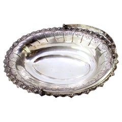 Silver fruit bowl with relief surround and articulated handle on four feet