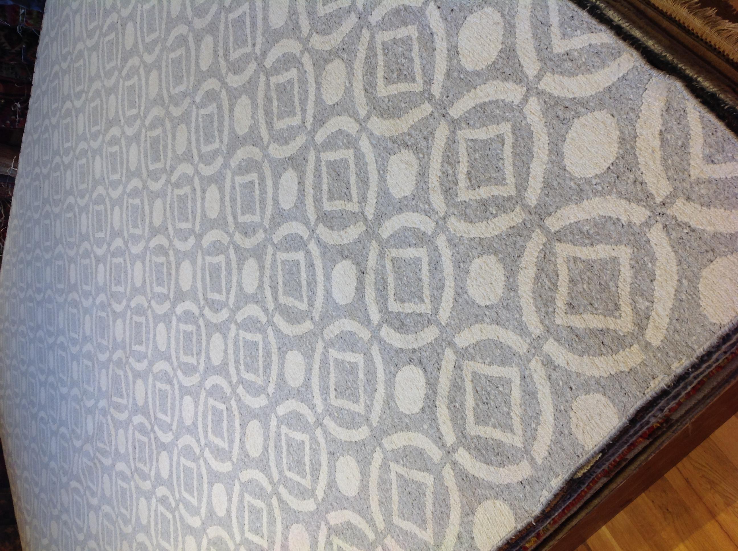 Diamonds and circles create an intriguing pattern in this contemporary wool area rug. Hand knotted wool construction creates a wonderfully nubby, and durable, texture. Made in India.