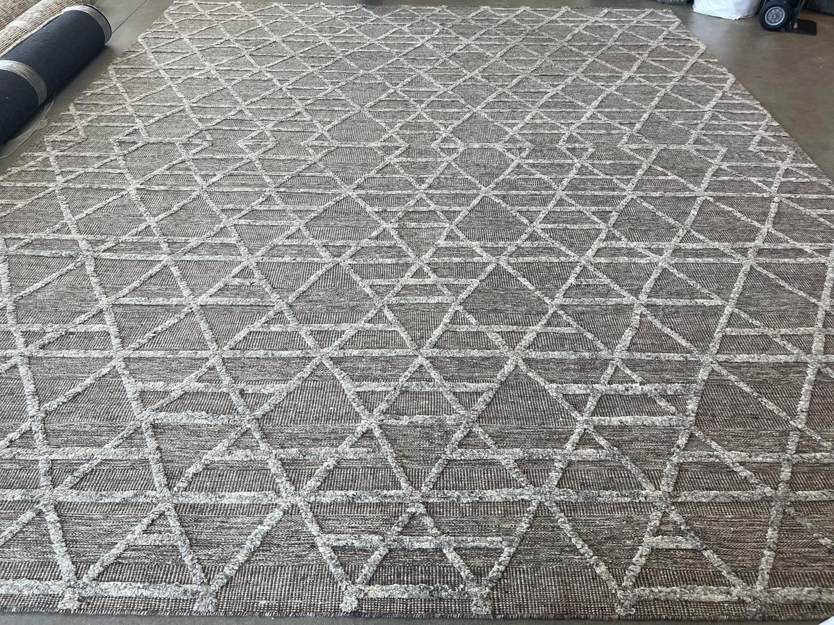 From the best-selling Mystique design series comes this exciting geometric patterned area rug in silver, grey and charcoal tones. Cut fibers against a woven backdrop create the layered effect that makes this rug stand out. Wool construction and