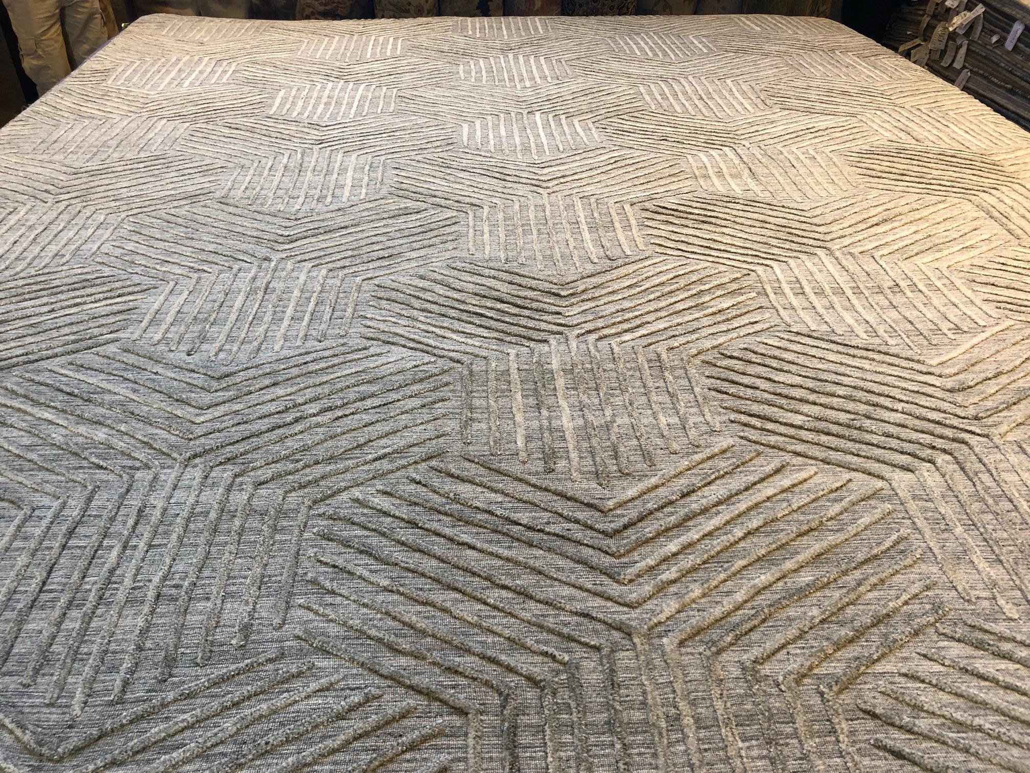 Lines and geometric shapes come together to create a vibrant pattern and texture in this hand knotted Indian wool rug. The neutral silver/grey tones make this a versatile addition to a wide range of spaces where it will enliven without overwhelming.