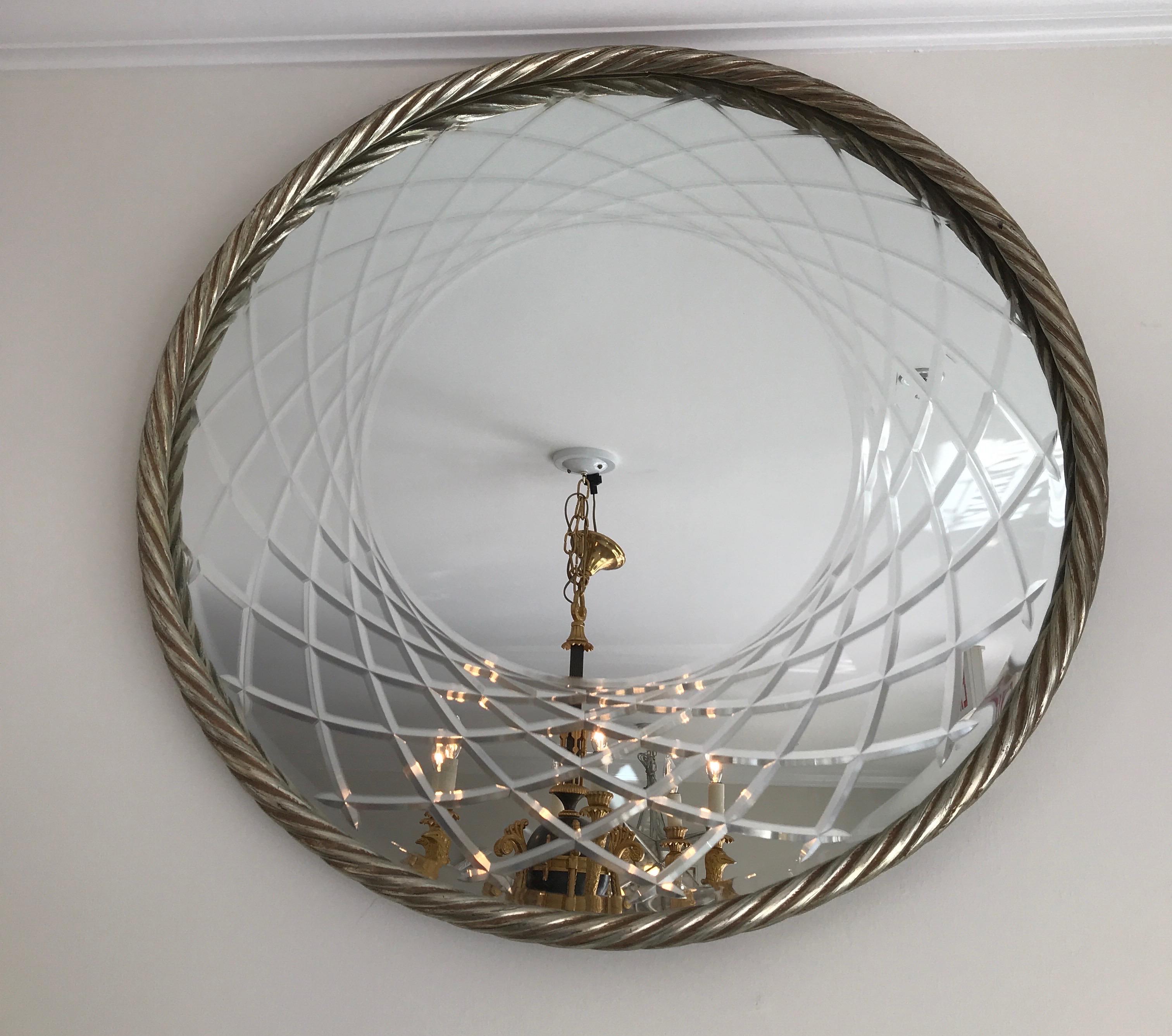 Silver gilded rope framed round mirror with a swirling design in border of mirror.