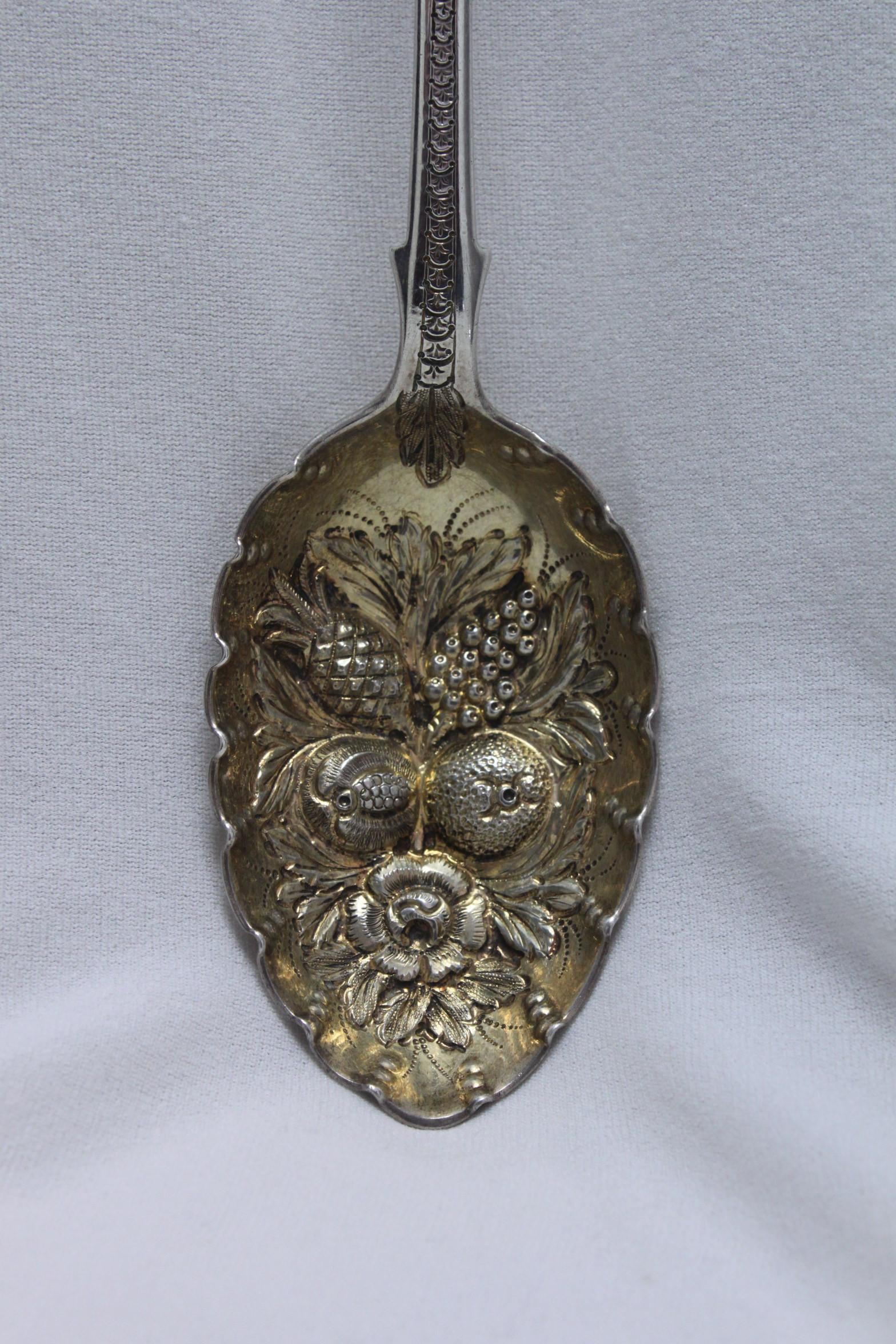 This lovely sterling silver berry spoon was made by James and Josiah Williams of Exeter and it carries the hallmarkmark for 1861. The ornate decoration leads from the fiddle pattern top of the handle down to the embossed bowl which features, amongst