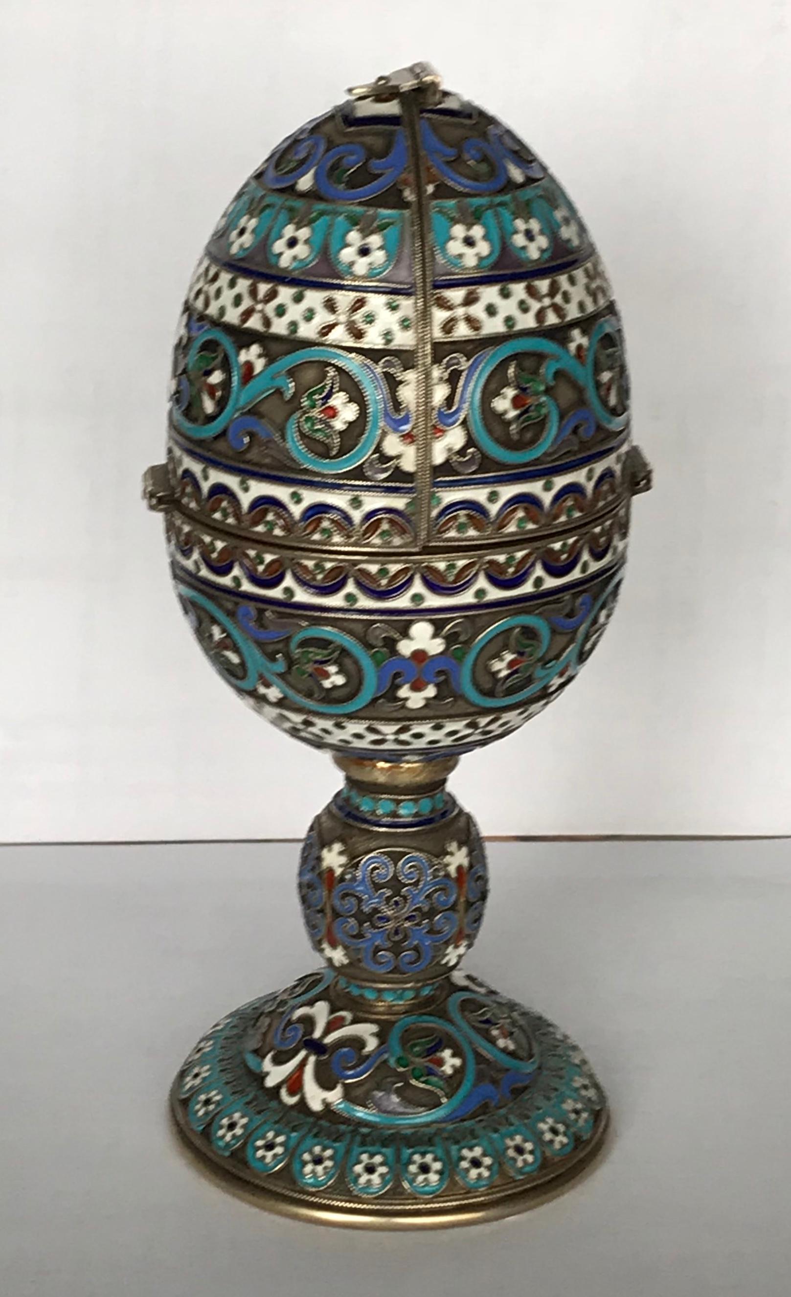 Ein silbervergoldetes Cloisonné-Emaille-Osterei.
Moskau 1908-26, Herstellerzeichen von Pavel Ovchinnikov (Moskau 1853-1916).
Eiförmig in zwei Hälften. Der obere Teil kann geöffnet werden. Das Innere enthält eine vergoldete Silberfigur eines