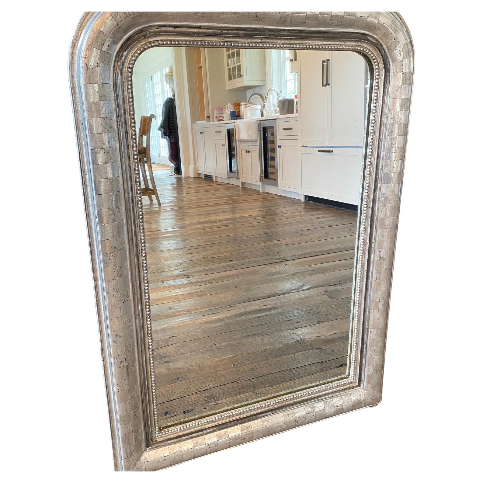 We love the simple form of this Louis-Philippe mirror. Rectangular, with rounded top corners, the mirror is silver leafed and features a lovely square geometric design with beaded edging on the frame. 
mirror measures 32.75 h 20.5 w
#6250.