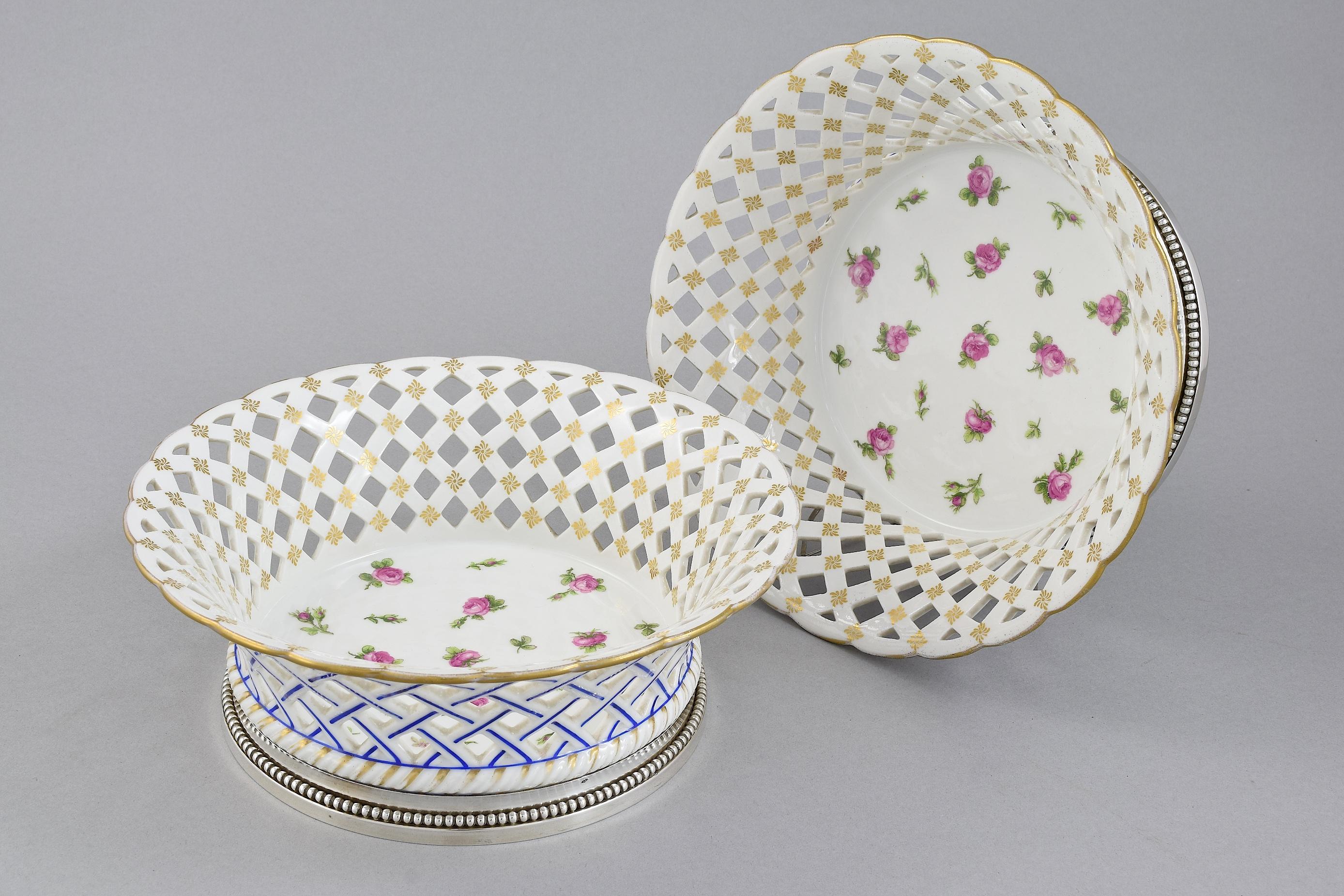 A pretty pair of silver gilt mounted porcelain baskets. French 1st standard (0.950). Makers mark for 'E.P' on the base which is likely for Emile Puiforcat. The pierced open work sides are intricately painted with flowers and gold trims.