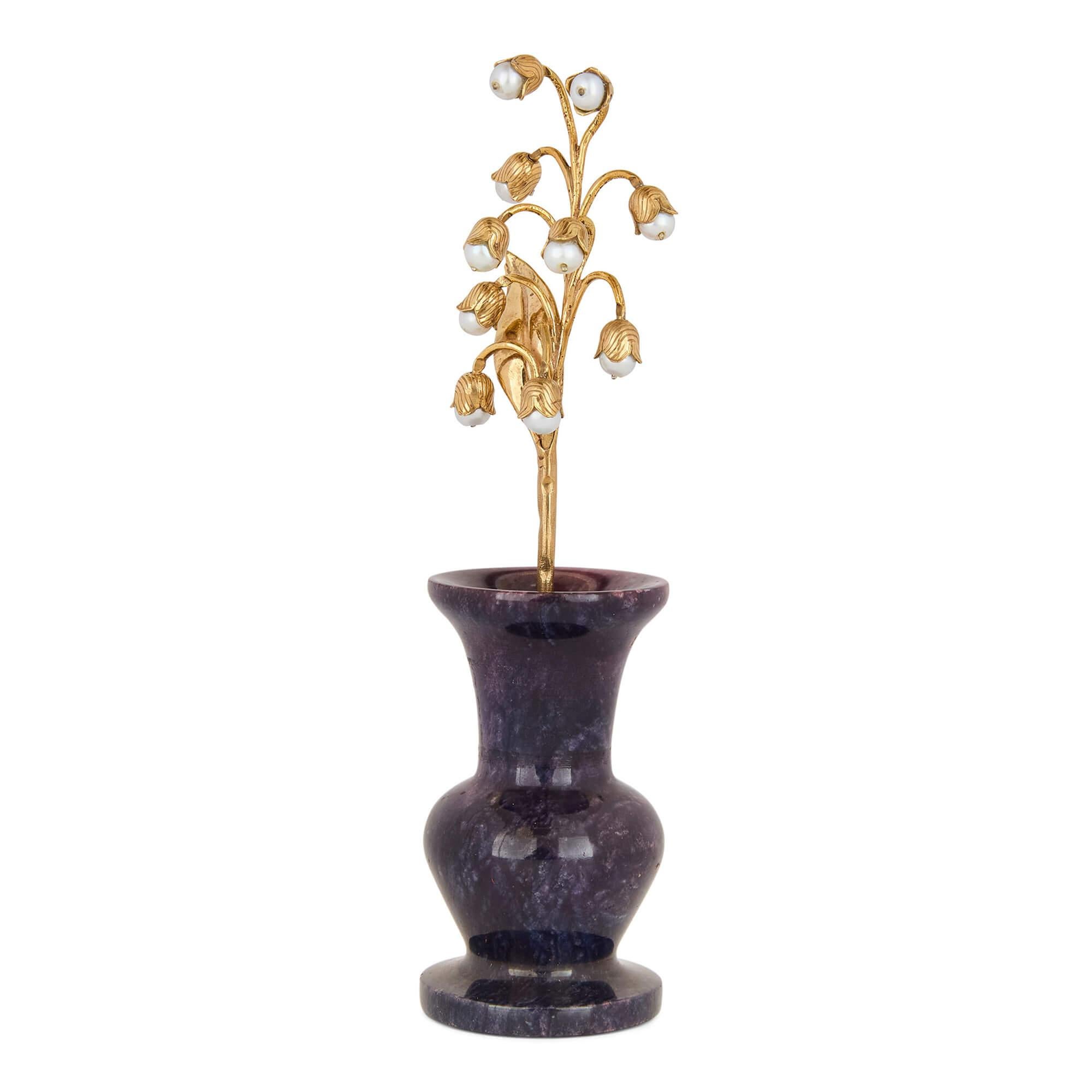 Modelo de lirio del valle de plata dorada, perlas y charoita al estilo de Fabergé
Continental, Siglo XX
Altura 15 cm, diámetro 4 cm

Esta exquisita escultura floral encarna la elegancia y la artesanía sinónimo de la tradición Fabergé. 

La base de