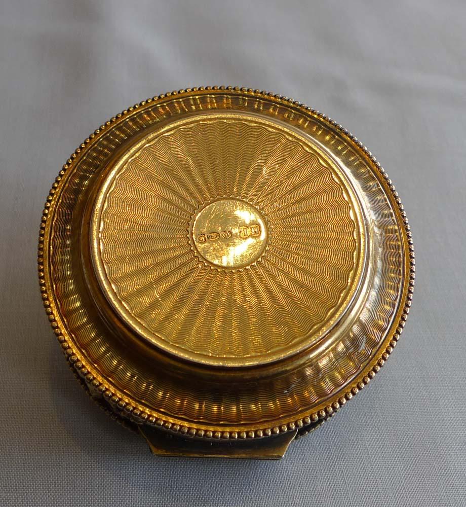 A silver gilt and jewelled pill box probably Austrian but with English import marks for London, 1905. Very fine quality with the silver gilt completely intact and mint within the box. The lid heavily engine turned with radii from the centre which