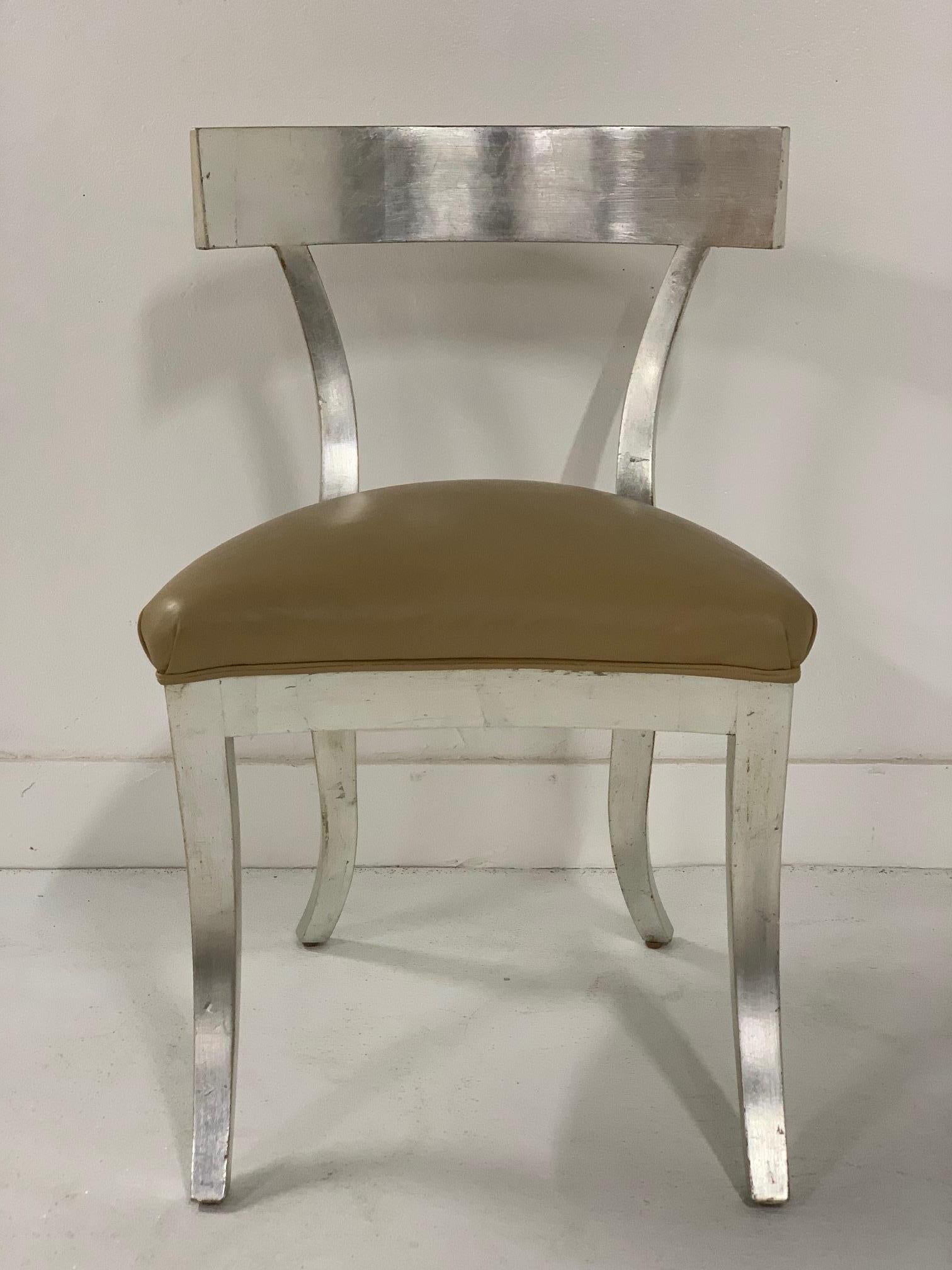 Silver gilt side chair style of Robsjohn-Gibbings. Has a leather seat and curved backrest.