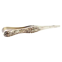 Silver glove stretching tweezers with reliefs on the handles