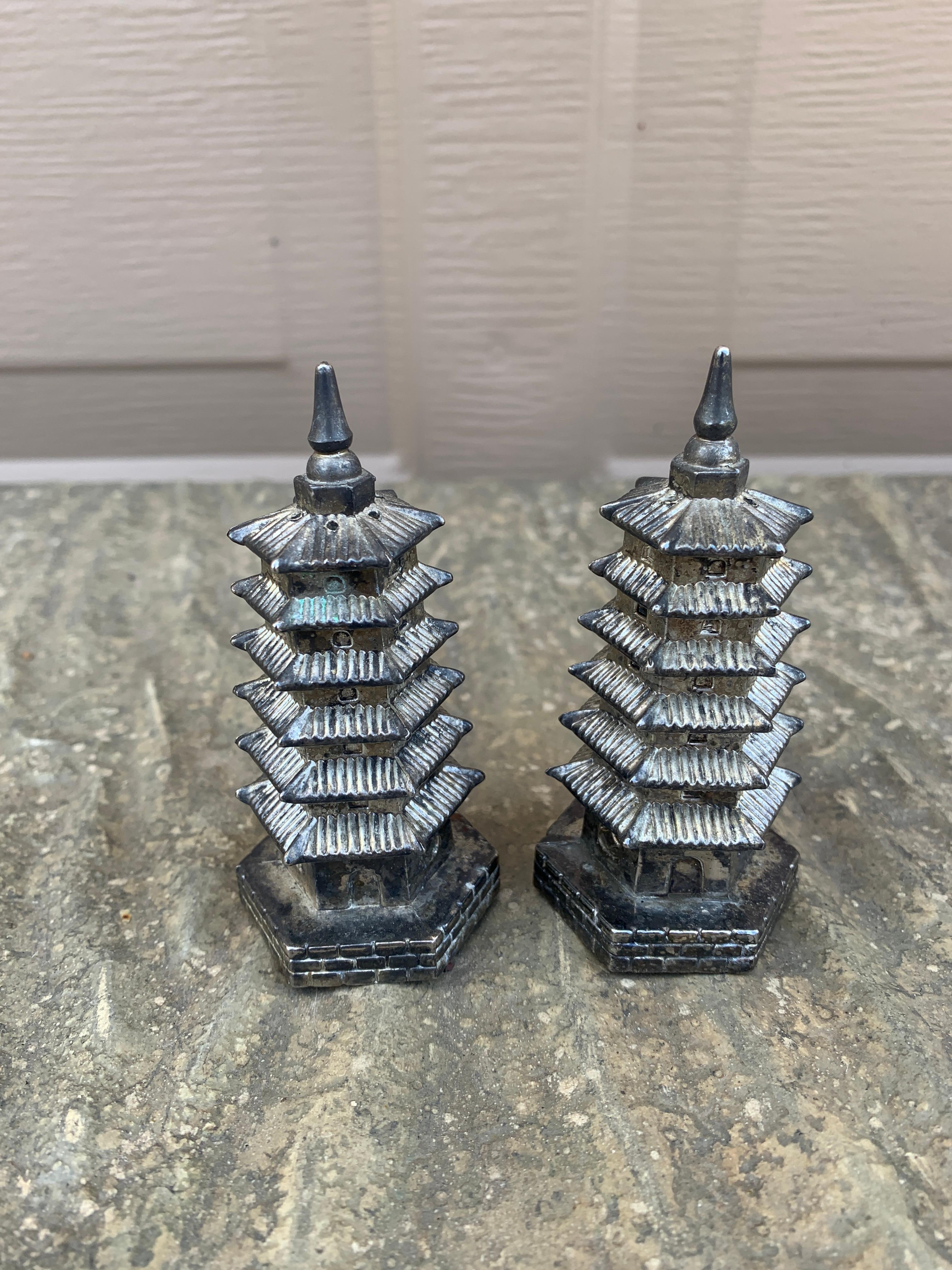 Un'affascinante coppia di saliere e pepiere in argento a forma di pagoda

Da Godinger

Circa anni '70

Misure: 1,5 