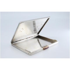 Boîtier en argent et or avec gravures florales et accents en pierre rouge.