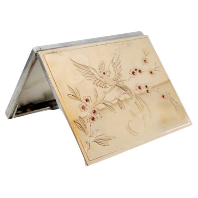 Silver-gold case with floral engravings and red stone accents