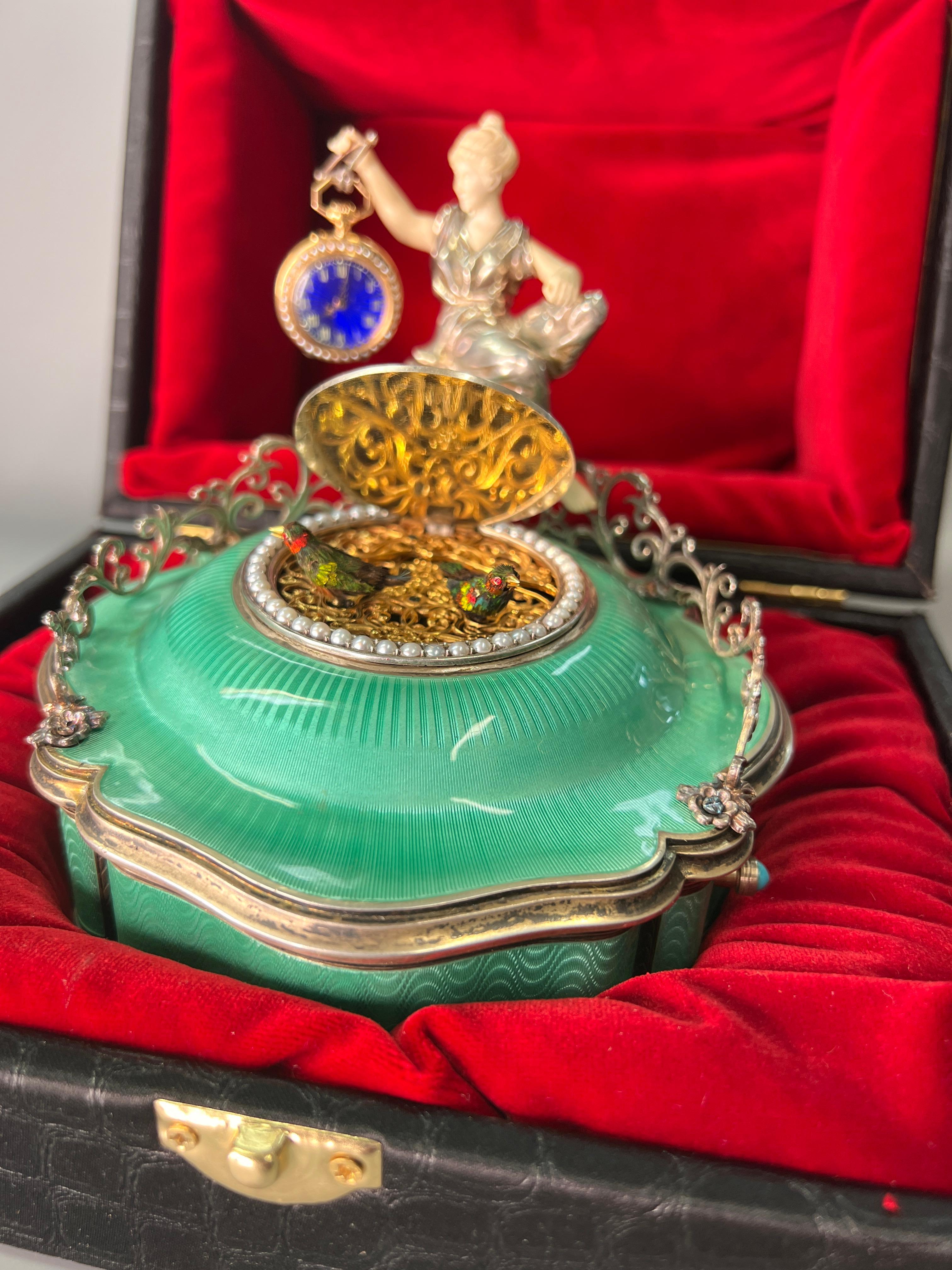This wonderful modern masterpiece has been created using original antique and vintage elements. The beautiful silver and guilloche enamel case dates to the early 20th century, the box upon pressing the start button reveals not one but two wonderful