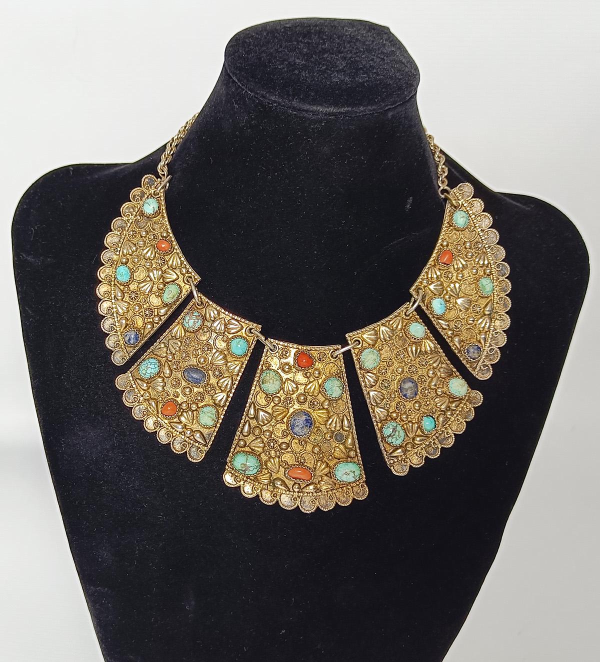 Silver gold gilt Persian bib necklace with turquoise Middle Eastern Antiques
A Highly detailed gold gilt metal Persian bib necklace influenced by the ancient style with turquoise and coral stones. 
Round and oval stones in filigree settings.  