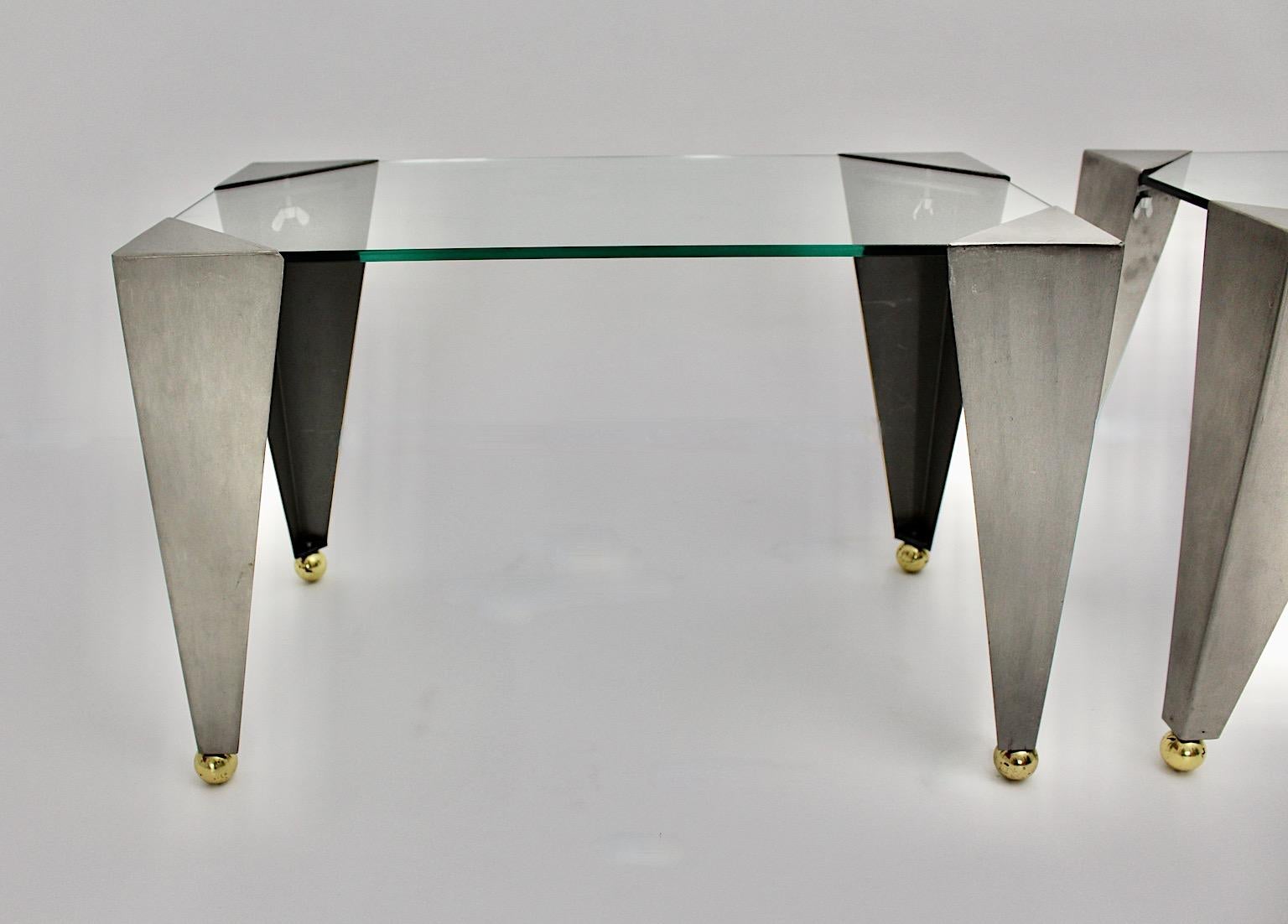 A pair of silver and gold vintage side tables or sofa tables made of stainless steel and brass which were designed and made out in the year 2000, Italy.
While the conical feet are composed of stainless steel and adjustable brass balls on their end,