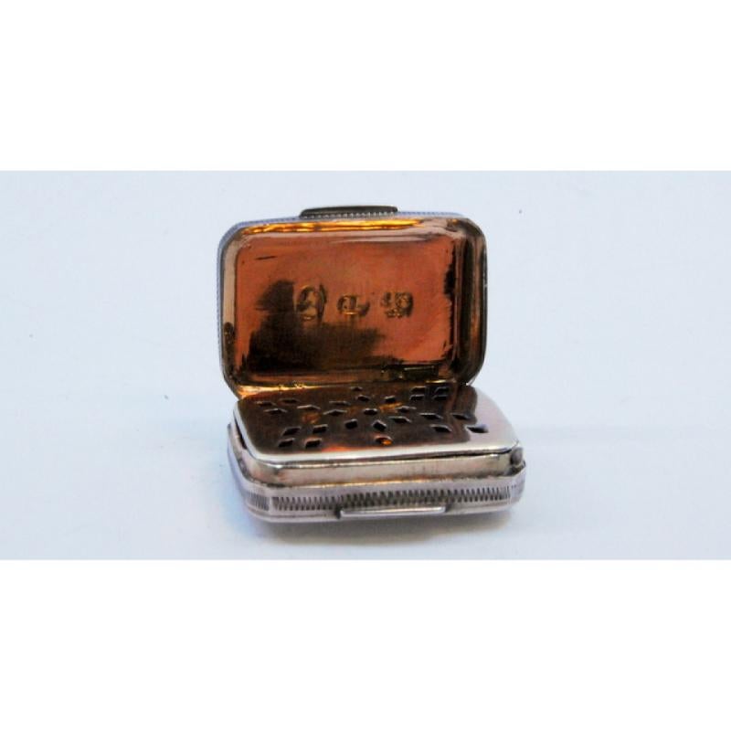 Description: Silver and gold vinaigrette box with asymmetrical engraving from the George III period. Metal: Silver. Origin: English. Brand: Birmingham. Weight: 5.68 grams. Dimensions: 2x1.5cm. Content: 925/1000 (silver) 375/1000 (gold). Assay Mark: