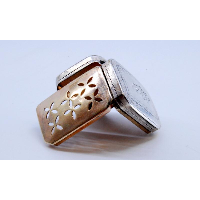 Descripción: Caja vinagrera de plata y oro decorada con grabados de la época de Jorge III en la tapa. Metal: Plata/Oro. Origen: Inglés. Marca: Birmingham. Peso: 6,84 gramos. Dimensiones: 2,5x1,9 cm. Contenido: 925/1000 (Plata) 375/1000 (Oro). Marca