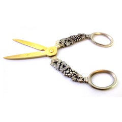 Silver grape scissors with raised bunches and golden ends