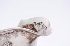 Silver gravy boat embossed with floral motifs