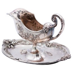 Silver gravy boat embossed with floral motifs