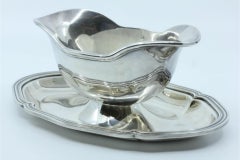 Silver gravy boat with a beaded platter around the edge