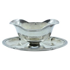 Silver gravy boat with a beaded platter around the edge
