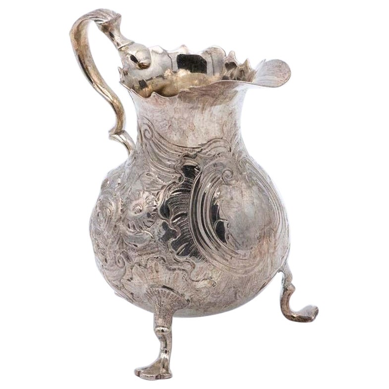 Silver gravy boat with embossed floral motifs