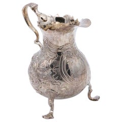 Silver gravy boat with embossed floral motifs