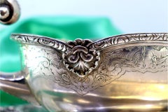 Silver gravy boat with engravings, friezes, and missing handle