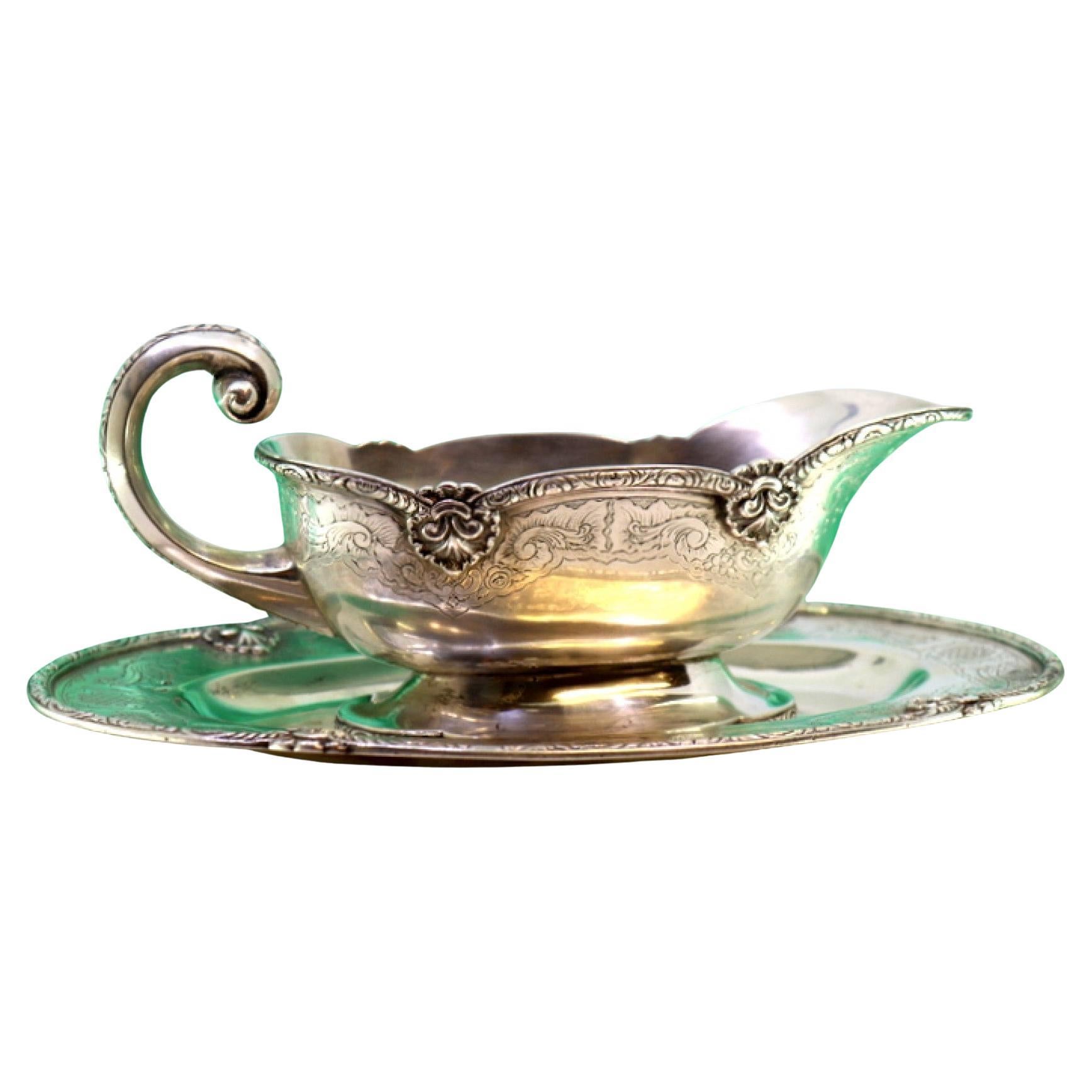 Silver gravy boat with engravings, friezes, and missing handle