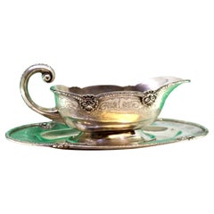 Silver gravy boat with engravings, friezes, and missing handle