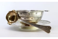 Silver gravy boat with floral motifs engraved on the plate, cup and spoon