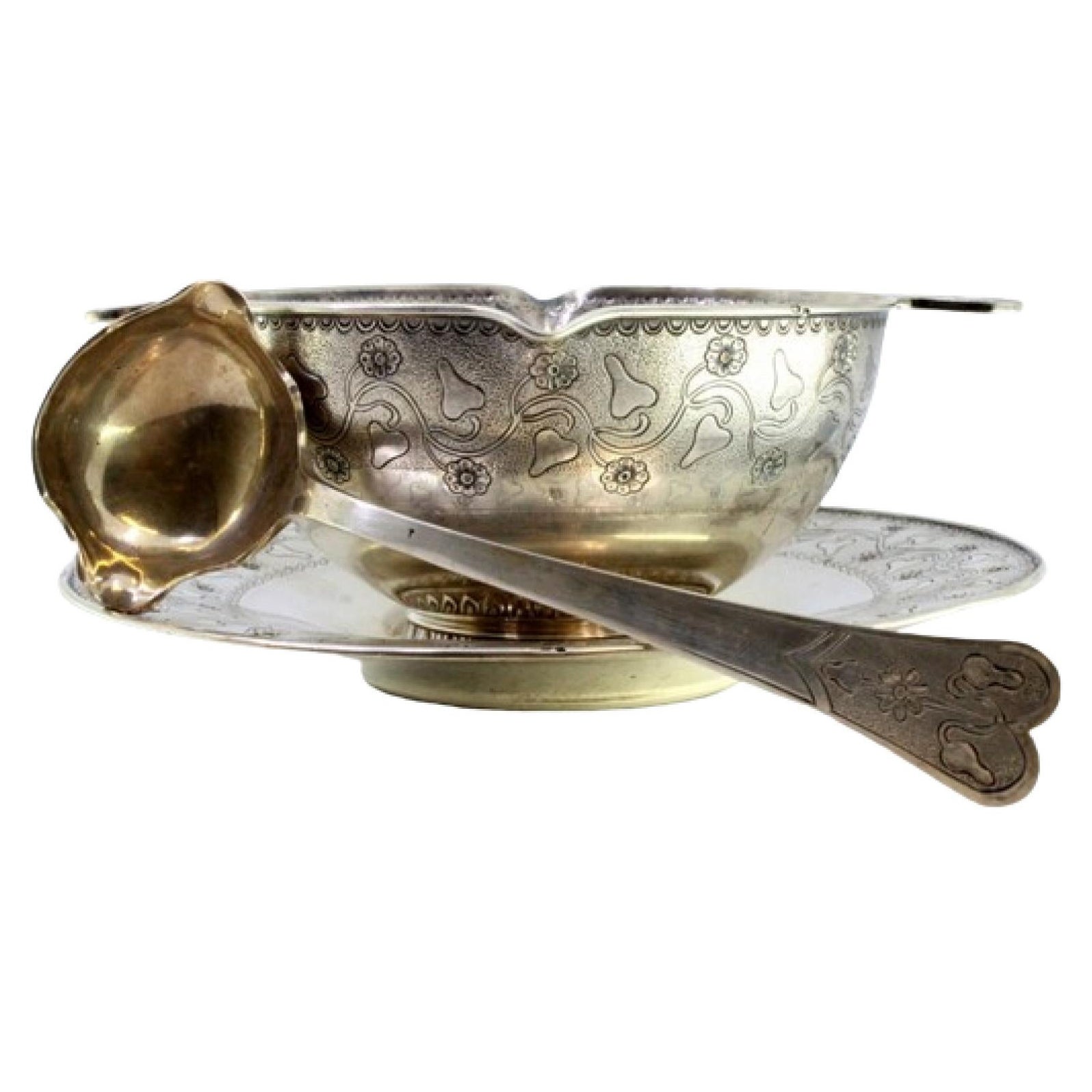Silver gravy boat with floral motifs engraved on the plate, cup and spoon