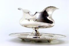 Silver gravy boat with two ladle holders and base with surrounding moldings