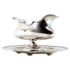 Silver gravy boat with two ladle holders and base with surrounding moldings