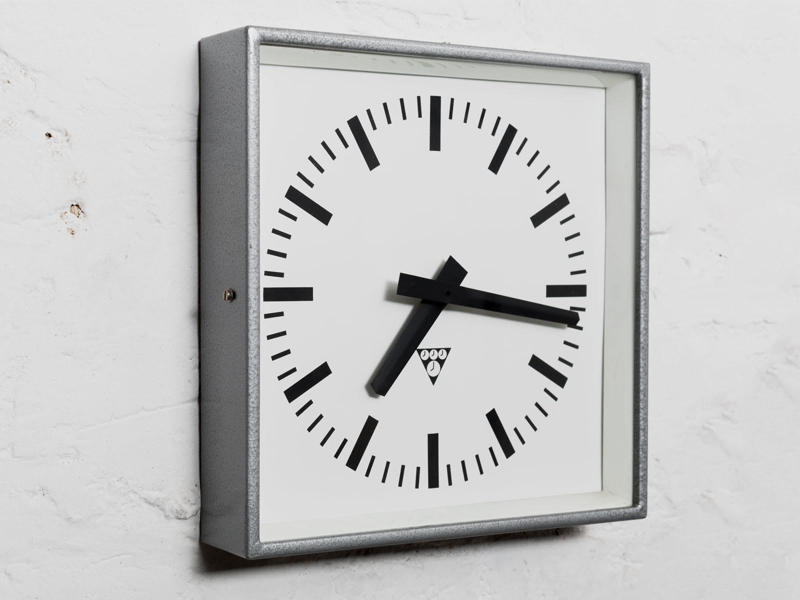 Industrial wall clock by Pragotron, 1970s. Originally used in factories, schools and railway stations. 
Silver Hammer paint body with clear glass cover. 
Converted to a battery powered clockwork -single AA battery.
