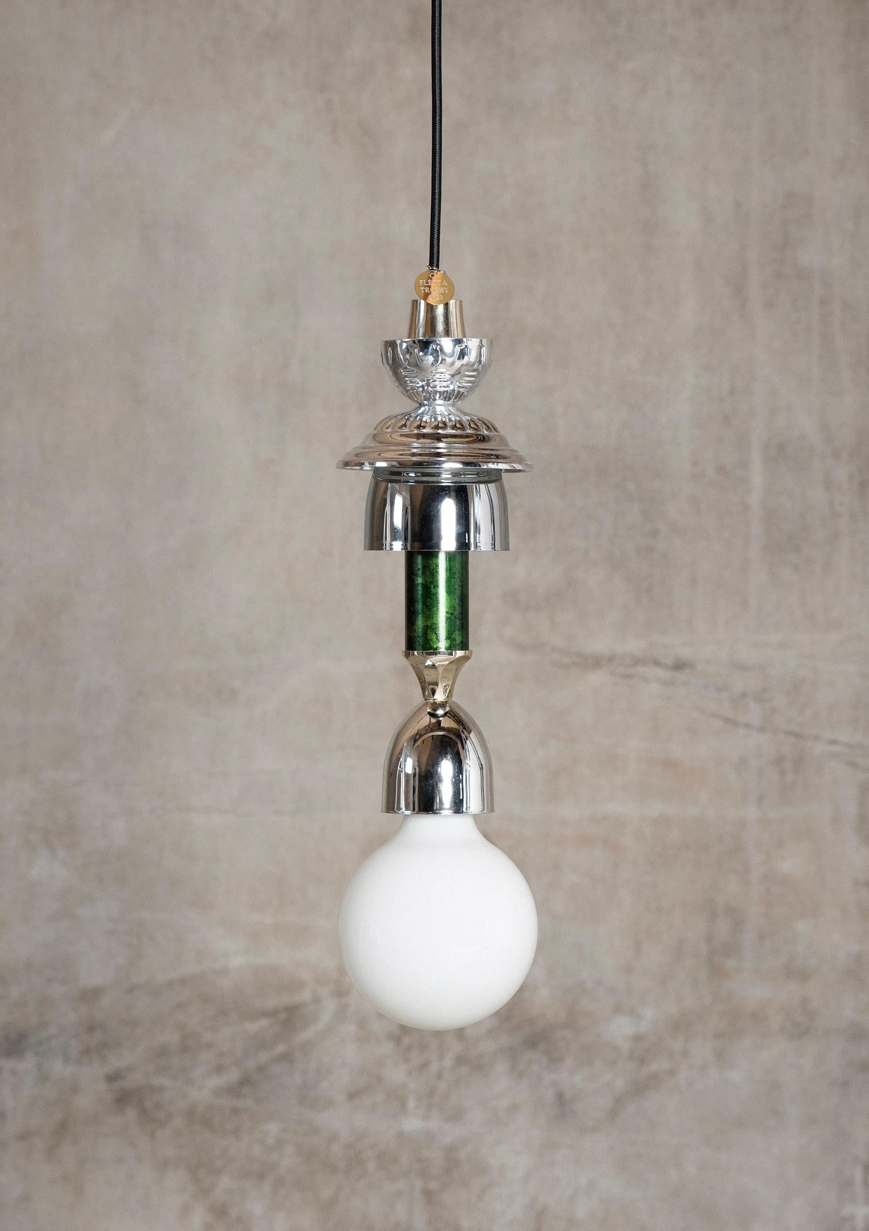 Silver, Green L3 Light by Flétta
Dimensions: 34 x 4 cm
Materials: silver

Trophy is a collection of tables, lights, flowerpots and shelves made of old trophies collected from athletes and sports clubs in Iceland. Trophies are a part of big