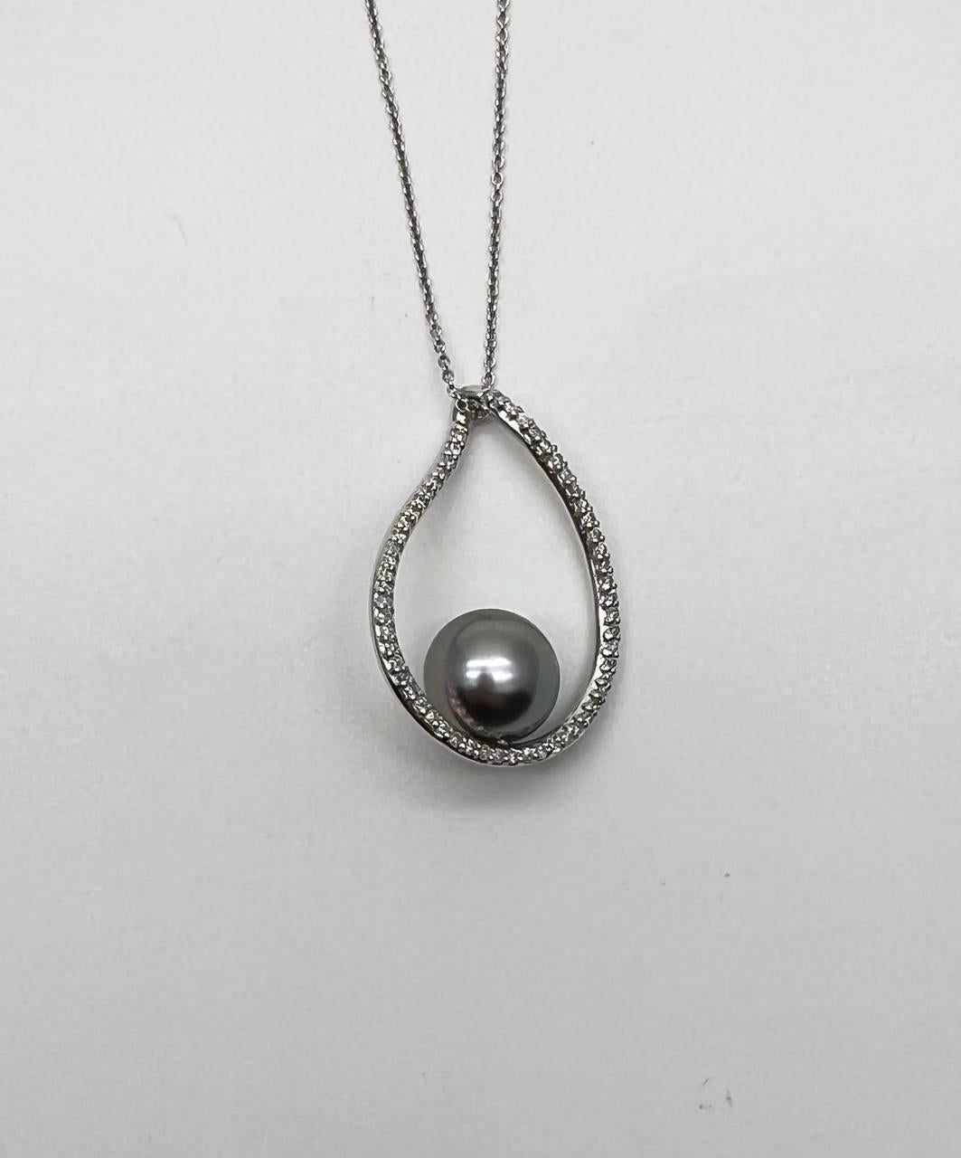 Questo squisito pezzo presenta una lucente perla di Tahiti incastonata in una cornice a forma di goccia.
La cornice è ornata da una serie di diamanti scintillanti che aggiungono un tocco di eleganza e raffinatezza.
Il ciondolo è sospeso a una