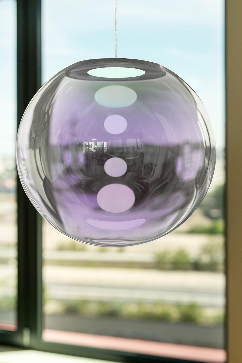 Silver-Lilac Iris Globe 40 by Sebastian Scherer
Handmade
Dimensions: Ø 40cm.
Design: Sebastian Scherer
Material: Dichroic-coated mouth-blown glass, stainless steel.
Color: Silver-lilac.

Available in gold-indigo, blue-orange, pink-green,