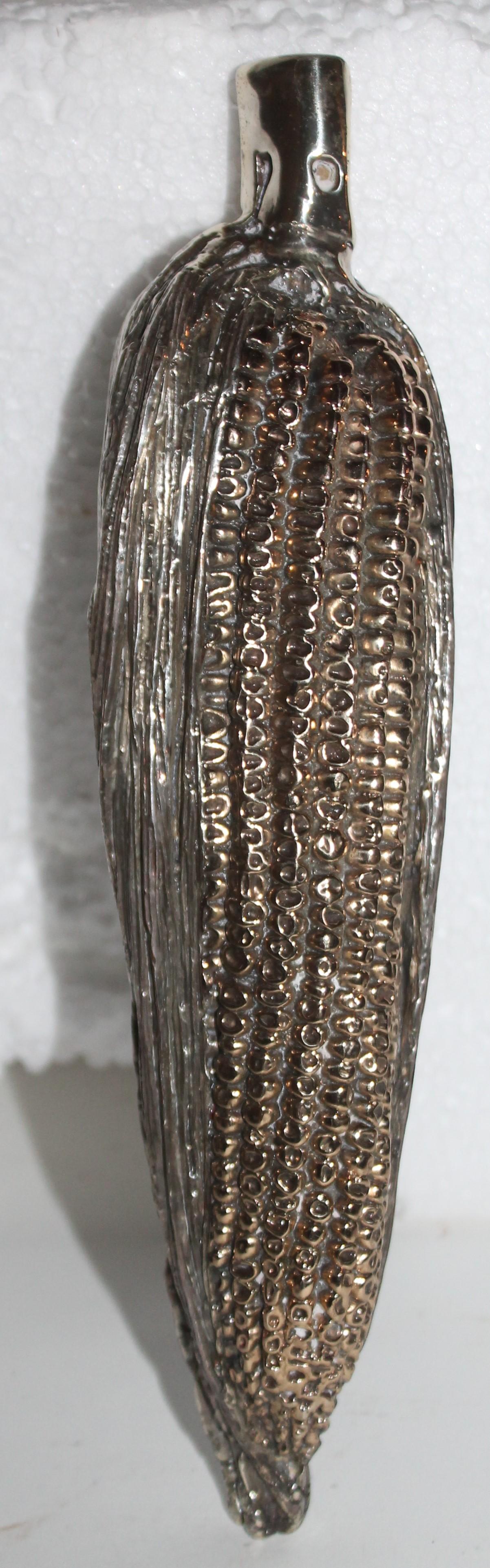 This sterling silver handmade heavy corn on the cob is unmarked and has gilded kernel's. This is a handmade item.