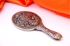 Silver hand mirror with revealed floral motifs