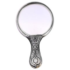 Silver hand mirror with revealed floral motifs