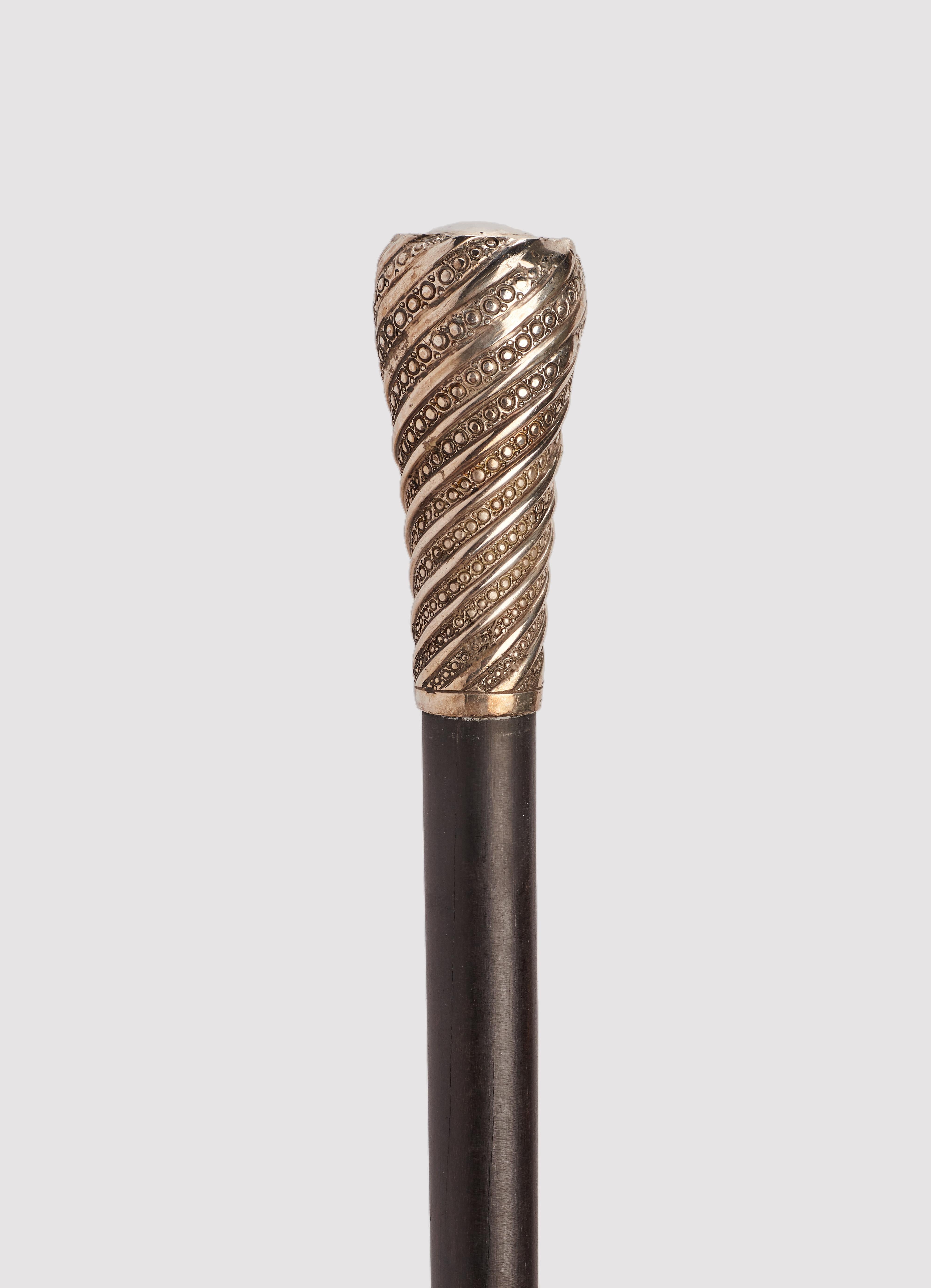 Walking stick: silver handle, milord shape tourchon. Eboney wood shaft. Metal ferrule. France 1900 ca.